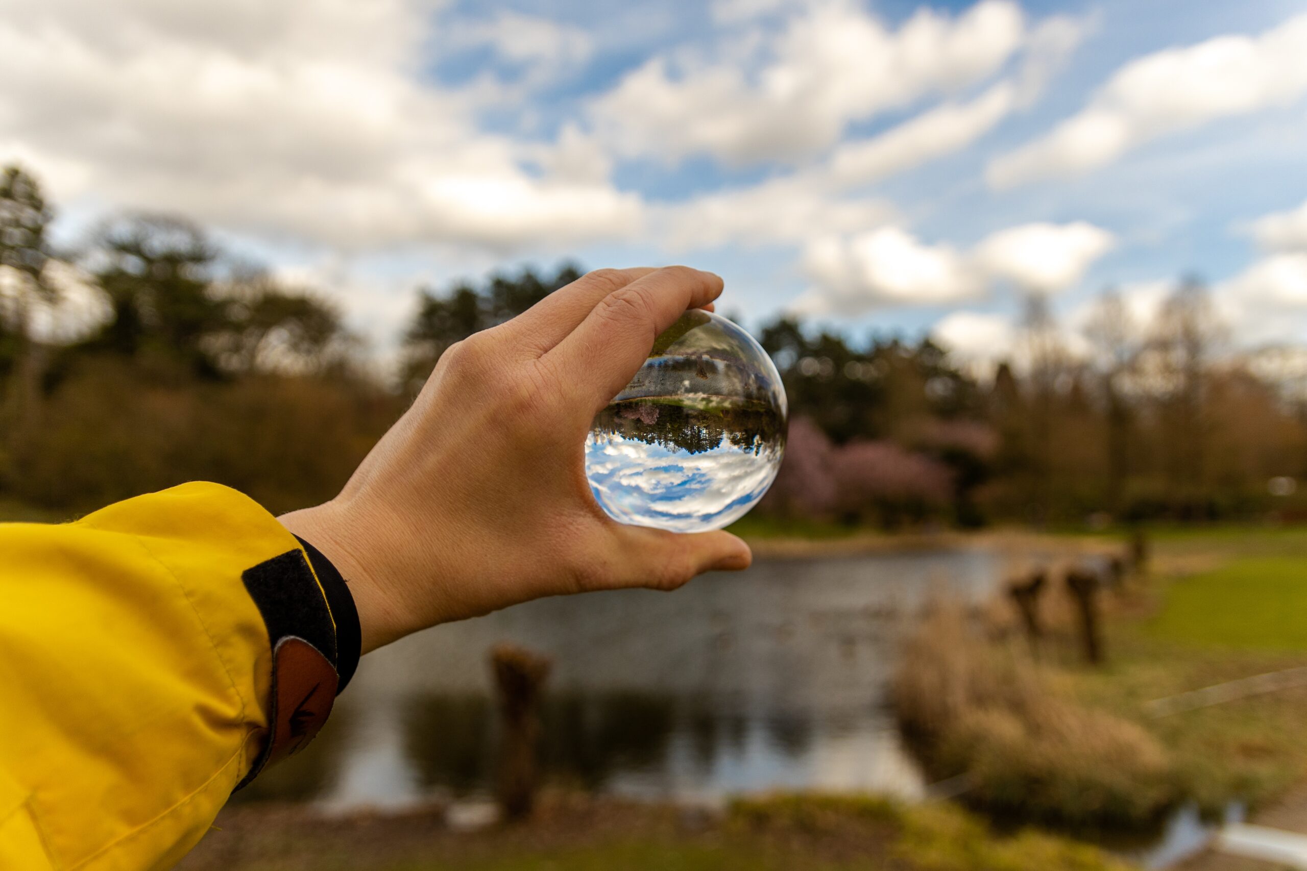 selective focus shot of a human hand holding a glass sphere